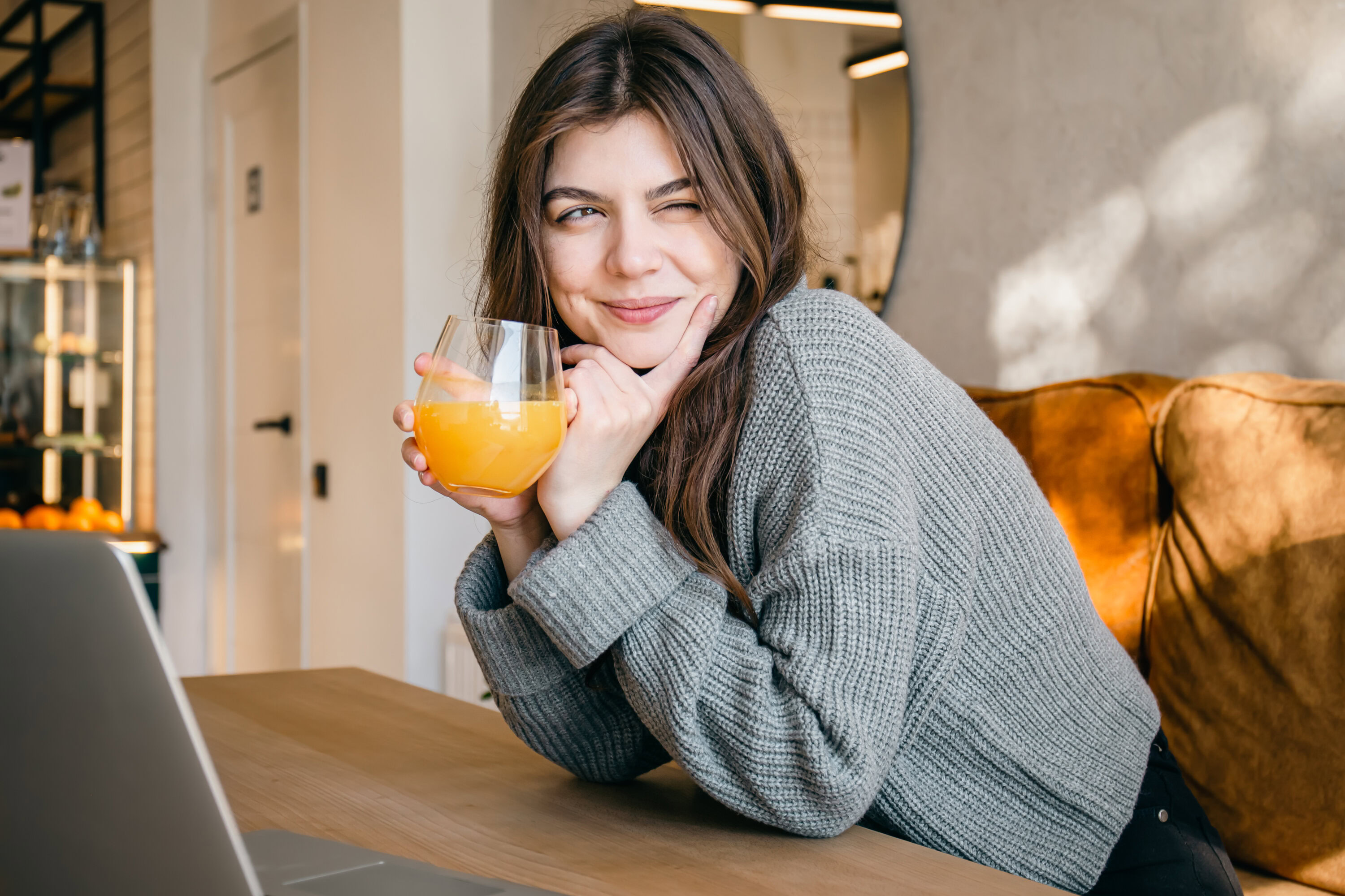 attractive young woman with a glass of freshly squeezed orange juice.